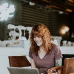 A woman sitting at a computer with a smile on her face.